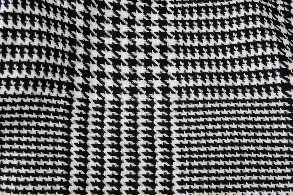 Kış kaşmir atkısı. Siyah ve beyaz kafes dokusu. Tekstil koyu renkli örgü arka plan.