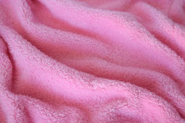 Yumuşak ve yumuşak pembe örülmüş kumaş. Tekstil kumaş arkaplanı.