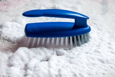 Yerleri temizlemek için mavi plastik fırça ve köpük. Ev temizliği kavramı.