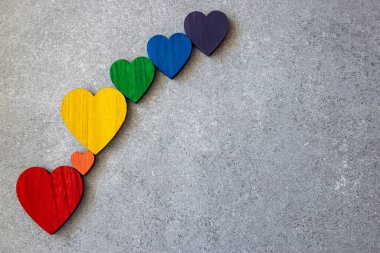 Taşın siyah zemininde gökkuşağının renkleri tahta kalpler. Lgbt bayrağı. 