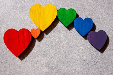 Taşın siyah zemininde gökkuşağının renkleri tahta kalpler. Lgbt bayrağı. 