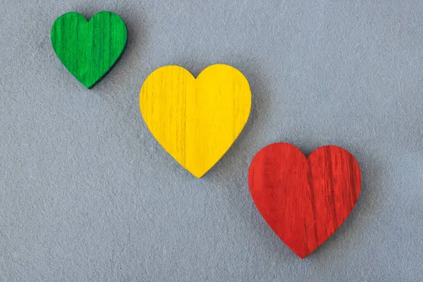 stock image Traffic light colors wood hearts on the gray fabric background. 