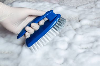 Temizlik için lastik eldiven ve fırça verin. Plastik mavi fırça ve yerdeki temizlik için beyaz köpük. Ev temizliği kavramı.