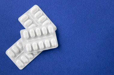 Mavi arka planda beyaz pakette bir sürü ilaç ve ilaç var. Sağlık sigortası konsepti. Metin için boşluk.