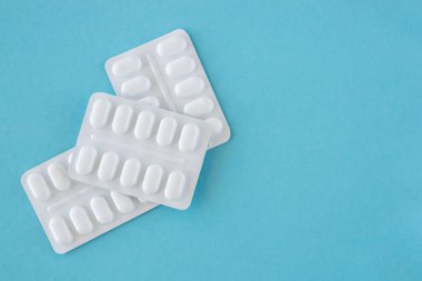 Mavi arka planda beyaz pakette bir sürü ilaç ve ilaç var. Sağlık sigortası konsepti. Metin için boşluk.