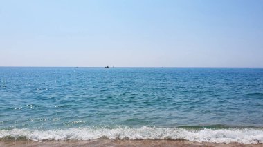 Kumlu güzel deniz, yatlar, dalgalar ve mavi gökyüzü. Yaz tatili için doğal arka plan.