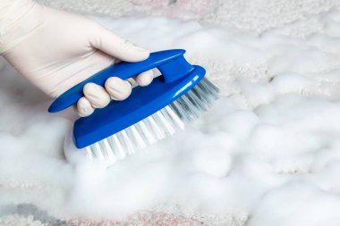 Temizlik için lastik eldiven ve fırça verin. Plastik mavi fırça ve yerdeki temizlik için beyaz köpük. Ev temizliği kavramı.