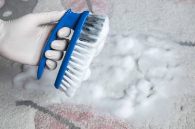 Temizlik için lastik eldiven ve fırça verin. Plastik mavi fırça ve yerdeki temizlik için beyaz köpük. Ev temizliği kavramı.