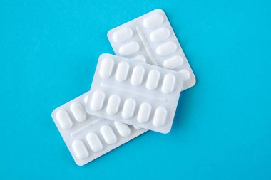 Mavi arka planda beyaz pakette bir sürü ilaç ve ilaç var. Sağlık sigortası konsepti. Metin için boşluk.