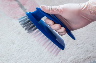 Temizlik için lastik eldiven ve fırça verin. Yerde plastik mavi bir fırça var. Ev temizliği kavramı.