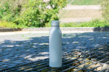 Ferahlatıcı suyu olan beyaz termo paslanmaz şişe doğada kalır..