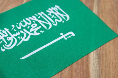 Doğal ahşap arka planda Suudi Arabistan bayrağı.