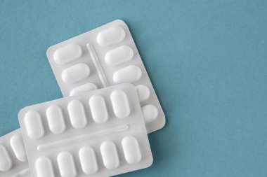 Mavi arka planda beyaz pakette bir sürü ilaç ve ilaç var. Sağlık sigortası konsepti. Metin için boşluk.