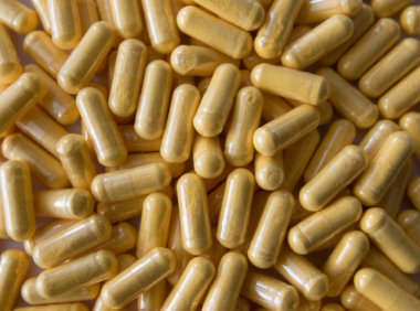 Siyah taş arka planda saydam pakette bir sürü tıbbi sarı hap ve uyuşturucu var. Sağlık sigortası konsepti. BAA ya da biyolojik olarak aktif katkı maddeleri.