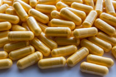 Siyah taş arka planda saydam pakette bir sürü tıbbi sarı hap ve uyuşturucu var. Sağlık sigortası konsepti. BAA ya da biyolojik olarak aktif katkı maddeleri.