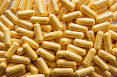 Siyah taşın üzerinde saydam pakette bir sürü tıbbi sarı hap ve uyuşturucu var. Sağlık sigortası konsepti. BAA ya da biyolojik olarak aktif katkı maddeleri.