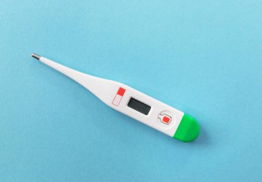 White digital thermometer for temperature measurement on beige background.