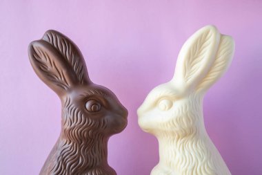 Pembe arka planda iki Paskalya tavşanı şeklinde çikolata..