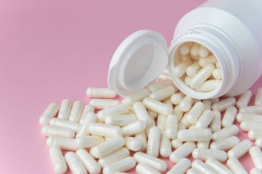 Pembe arka planda beyaz pakette bir sürü ilaç ve ilaç var. Sağlık sigortası konsepti. Metin için boşluk.