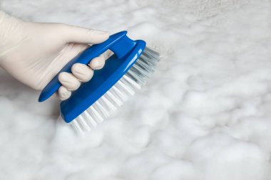 Temizlik için lastik eldiven ve fırça verin. Plastik mavi fırça ve yerdeki temizlik için köpük. Ev temizliği kavramı.