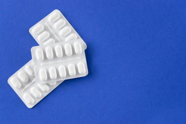 Mavi arka planda beyaz pakette bir sürü ilaç ve ilaç var. Sağlık sigortası konsepti. Metin için boşluk.