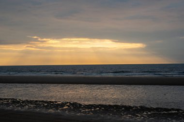 Akşamları güzel deniz kenarında sahilde gün batımı. Güzel sarı güneş ışığı. Ostende, Belçika 'da Tatil.