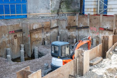 Şehirdeki bir binanın inşaatı sırasında çalışıyorum. Eski bir binayı yıkmak için kazıcı ve buldozer.. 