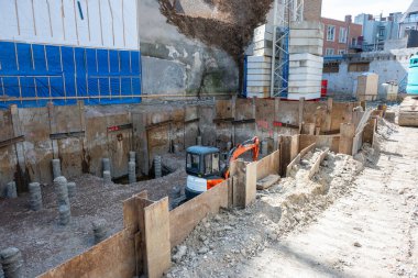 Şehirdeki bir binanın inşaatı sırasında çalışıyorum. Eski bir binayı yıkmak için kazıcı ve buldozer.. 