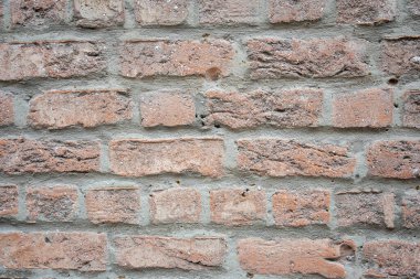 Eski binanın kahverengi ve gri yapısal taş duvarı tuğlalardan oluşur. Doğa yapısal arkaplan.