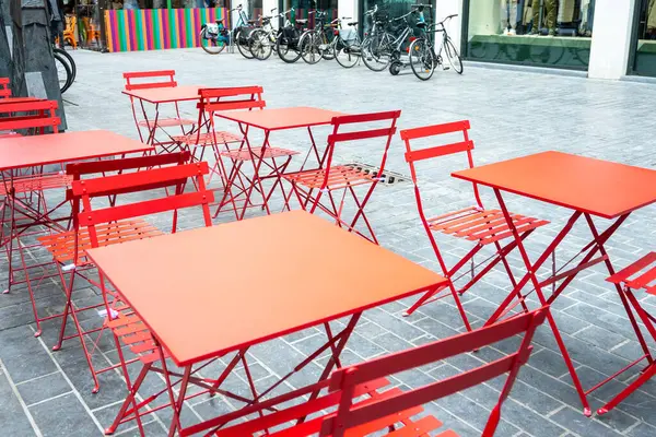 Cafe açık havada. Dışarıda kırmızı metal sandalyeler ve masalar Fransa 'da yaz güneşi havası olan caddelerde. Yaz kafesi veya restoranı için mobilya dizaynı.