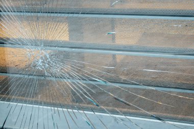 Yakın binada büyük ve küçük çatlaklar olan eski kırık camlar. Şehir caddesinin manzarası ve koruması olan kirli pencere..