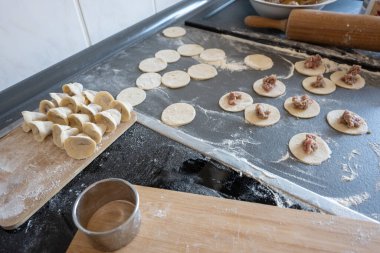 Mutfaktaki gri masada hamur köftesi hazırlayan adam. Yiyecek konsepti