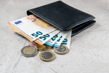 Avro parası olan siyah bir parti. Ticaret konsepti için deri cüzdandaki bozukluklar ve faturalar..