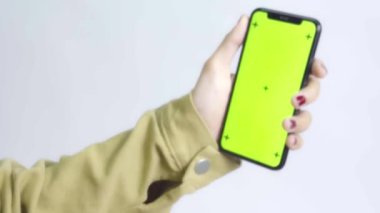 Yeşil Ekran Chroma Anahtarı Tanınmayan zeytin tenli Asyalı kadın beyaz arka planda cep telefonunu kullanıyor. Dikey oryantasyon. Ekranın ortasına tıklayarak dokunun