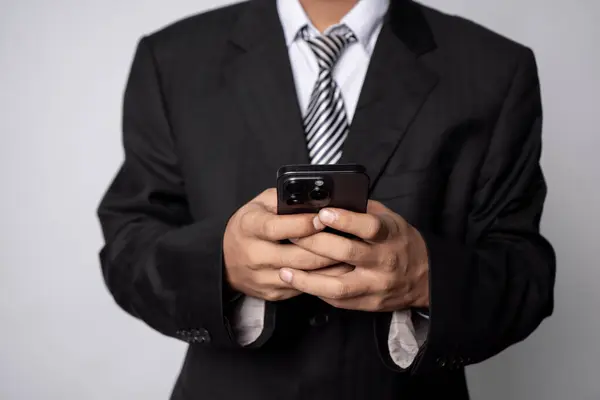 Genç işadamı akıllı telefon tutuyor.