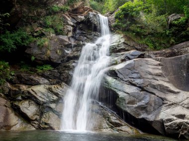 Burdeiver Deresi 'nin oluşturduğu güzel bir şelalenin uzun pozlama sahnesi. Valchiusella, Piemonte, İtalya 'da Fondo yakınlarında kayalar ve ağaçlarla çevrili..