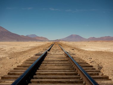 Chiguana tuz düzlüklerinde paralel raylar, Bolivya dağları, Güney Amerika. Ufuktaki serap etkisi.
