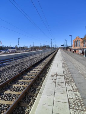 Raylı ve binalı tren istasyonu devriyesi.