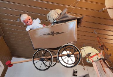 Evin içinde asılı bebekleri olan klasik bebek arabası.