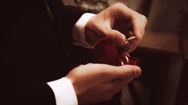 Masada kravatlı kırmızı elbiseli bir adam var.