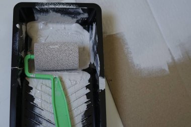 Tamir konsepti, plastik boya kabında yeşil saplı boya silindiri. Yüksek kalite fotoğraf