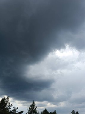 Yağmurdan önce fırtına bulutlarıyla dramatik bir gökyüzü. Fırtınalı gökyüzü ve kara bulutların panoramik görüntüsü. Hava durumu, doğal afetler, tayfun teması. Yüksek kalite fotoğraf. Taşınabilir dikey fotoğraf