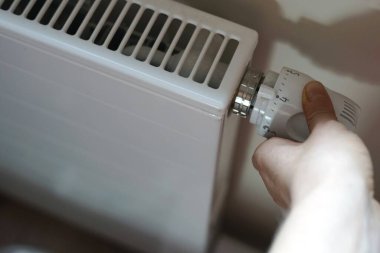 Kadın elinde radyatör termostat kapakçığı ayarları soğuk sonbahar kış serasını ayarlar. Yüksek kalite fotoğraf