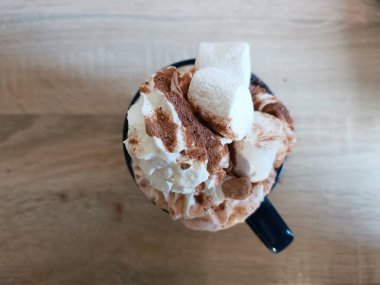 Üst manzara, sıcak çikolatalı krem şanti mavi kupa ahşap masa sıcak kış. Yüksek kalite fotoğraf