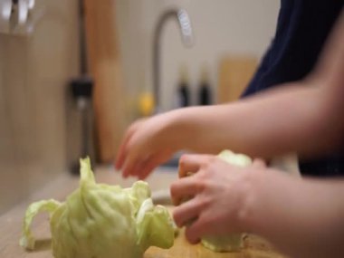 Video anne kızı birlikte yemek pişiriyor lahana mutfağını kesiyor öğle yemeği tahvilini küçük bir yardımcı yapıyor. Yüksek kaliteli HD görüntüler