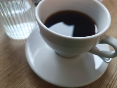 Su şişesi ahşap masa ile sade beyaz kahve. Sabah kahvaltısı. Yüksek kalite fotoğraf