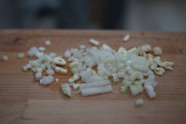 Taze doğranmış soğan ve sarımsak ahşap kesim tahtasına saçılmış, yemek ve yemek hazırlamak için mükemmel..