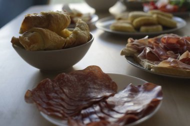 Taze hamur işleri, pişirilmiş etler ve renkli eşliklerle nefis bir sabah yemeği veya brunch yemeği için mükemmel bir ziyafet..