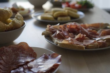 Haşlanmış etler, taze pişmiş hamur işleri ve renkli sebzeler içeren canlı bir şarküteri. Toplama ve kutlamalar için mükemmel..