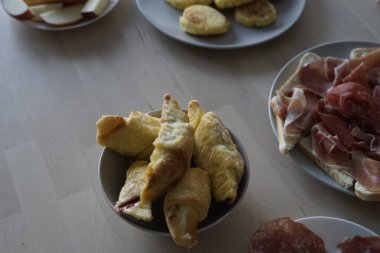 Lezzetli hamur işleri, çeşitli etler ve taze elmalar içeren cazip bir kahvaltı, nefis bir sabah yemeği için mükemmel..